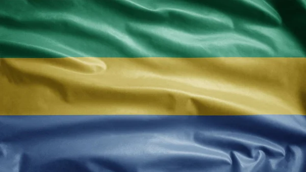 加蓬国旗在风中飘扬 靠近加蓬的旗帜 柔滑柔滑的丝绸 布料质地为背景图案 将其用于国庆日和国庆日概念 — 图库照片