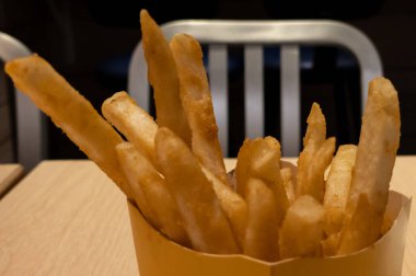 Restoranda hamburgercinin içinde patates kızartması servis ediliyor. Lezzetli kızarmış patates atıştırmalıkları. Fast food ve sağlıksız yeme konsepti