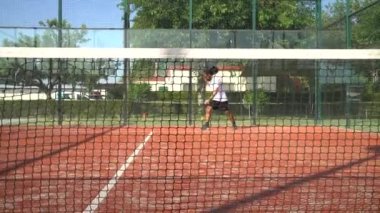 Seville, İspanya-21 Temmuz 2021: Padel oyuncusu topu açık havada birkaç kez sektirdikten sonra servis atıyor. İnternetten görüntüle.