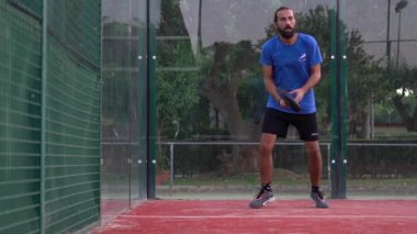 Seville, İspanya-03 Ağustos 2021: Açık sahada çalışan bir raket tenisçisinin yavaş hareketi. Raketiyle birkaç topa vuruyor..