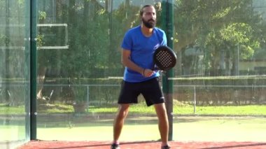 Seville, İspanya-03 Ağustos 2021: Profesyonel bir raket tenisçisinin açık hava sahasındaki bir maçta topa vurması ağır çekim.