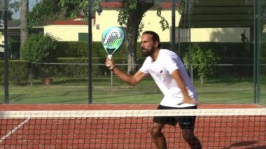 Seville, İspanya-21 Temmuz 2021: Erkek bir Padel oyuncusunun açık havada farklı teknikler denemesi.