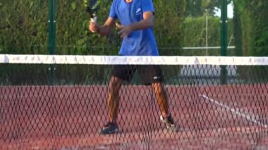 Seville, İspanya-28 Temmuz 2021: Açık hava sahasında yarışan bir raket tenisçisinin yavaş çekimi. Mahkeme ağından görüntüyü izle.