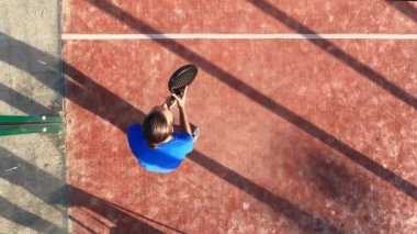 Dışarıdaki sahada raket oynayan bir adamın manzarası. Spor yapma kavramı.