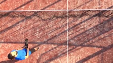 Profesyonel bir raket tenisçisinin açık hava sahasında topa vuruşunun en üst görüntüsü..