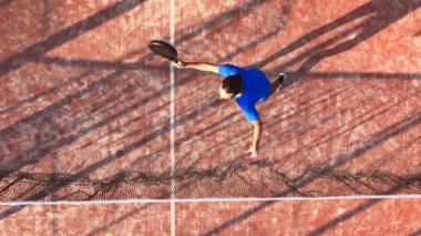 Bir raket tenisçisinin açık hava sahasında topa vuruşunun tepe noktası..