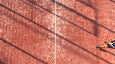 Açık havada tenis oynayan bir adamın topa vuruşunun üst görüntüsü..