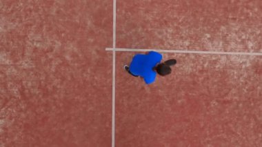 Dış sahada raket oynayan bir adamın en iyi görüntüsü. Beyaz çizgilerin üzerinde yer alıyor..