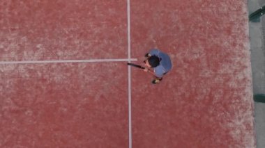 Bir raket tenisçisinin açık hava sahasında oynamayı öğrenmesinin en iyi görüntüsü.