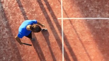 Top servis sırasında topa nerede vurulacağını gösteren bir Padel öğretmeninin üst görüntüsü. Açık sahada raket tenis okulu.