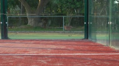 Top, açık hava raket tenis kortunun duvarına çarpıyor..