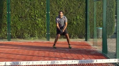 Açık havada tenis oynamayı öğrenen bir adamın ağır çekimde. Spor antrenmanı konsepti.