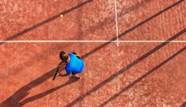 Açık hava sahasında Padel maçı yapan profesyonel bir raket tenisçisinin üst görüntüsü.