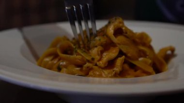 Restoranın masasında ağır ağır spagetti bolonez yiyorlar. Lezzetli tipik İtalyan domates soslu makarna tarifi beyaz tabakta servis edilir. Geleneksel İtalyan mutfağı.