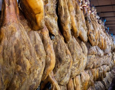 Kurutulmuş domuz butları et pazarında asılı duruyor. Marketteki İspanyol jambonu ya da jambonu. İspanya 'da İber domuzu alışverişi. Kuru ve kurutulmuş jambon. Piyasa çiğ et ürünleri satıyor