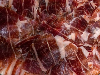 Jamon Serrano olarak da bilinen İspanyol kurutulmuş domuz dilimlerine yakın çekim. Tipik leziz tapa tabağı İber usulü jambon tabağı masada, İspanya 'nın geleneksel yemekleri.