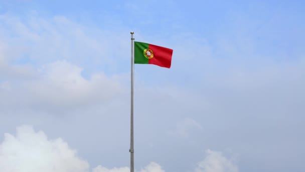 ポルトガルの国旗が青い空と雲で風になびく 柔らかい絹を吹くポルトガルの旗 布生地の質感が背景を刻印 国民の日や国の機会の概念のためにそれを使用してください — ストック動画