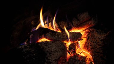 Kızgın ateş ve şöminede kırmızı kömür. Bacada odun yakmak ve kışın ortam sıcaklığı. Ateşin parlak alevi