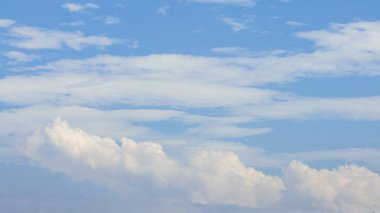 Güneşli bir yaz gününde mavi gökyüzü olan kümülüs bulutları. Doğa arkaplan manzarası olarak güzel bulutlar. Beyaz bulutların yüzdüğü, soyut bir şekil oluşturan doğal gün ışığının harika havası.