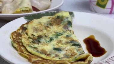 Lezzetli Çin omleti, tabakta peynir ve Taipei restoranında bambu çubuklarıyla birlikte. İçinde sarı yumurta, peynir ve el yapımı krep var. Tayvan 'da popüler kahvaltı yemekleri