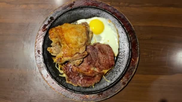 安価なステーキハウスレストランでテーブルの上の鉄板の上にパスタや卵と台湾ナイトマーケットステーキ 通りの台湾料理の人気とおいしい料理 — ストック動画