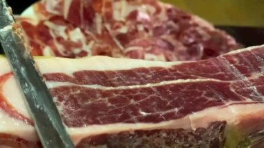 İspanyol Pata Negra olarak da bilinen Serrano İberya jambonu 'nun ön ayağı bir kasapla birlikte tahta tezgahın üzerine monte edildi.