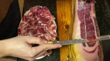 İspanyol Pata Negra olarak da bilinen Serrano İberya jambonu 'nun ön ayağı bir kasapla birlikte tahta tezgahın üzerine monte edildi.