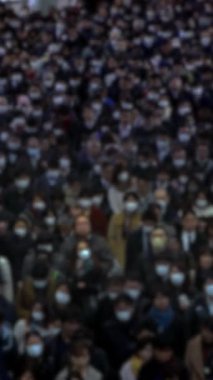 Tokyo 'da ilerleyen Asyalı yolcuların bulanık dikey görüntüsü şehir hayatının ezici temposunu anımsatıyor. Odaklanmamış detaylar anonimlik ve kaos duygusunu arttırır..