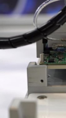 Factory machinery at work. PCB Processing on CNC machine. Production of electronic components at high-tech factory. Circuit board being assembled with automated robotic arm.