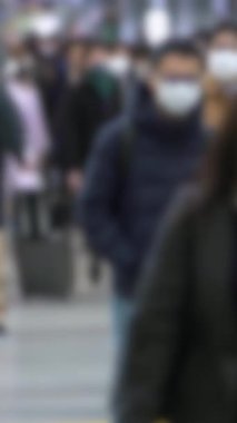 Tokyo 'daki kavşakta yürüyen Asyalı banliyö sakinlerinin dikey görüntülerinin dağılması, modern rutin, toplumsal ritim ve şehir ortamlarında anonimliği akla getiriyor..