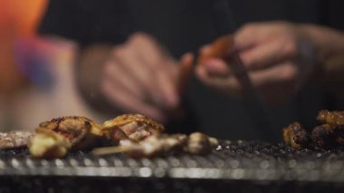 Gece Fukuoka 'da sıcak, dumanlı ve yemek pişirme sesleriyle çevrili bir Japon yatai standında yemek pişiren bir aşçıyı ağır çekimde yakalamak.