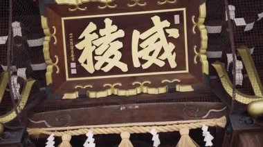 Fukuoka, Japonya-02 Ekim 2025: Geleneksel Japon kültüründe iyi şans ve sağlığı simgeleyen Fukuoka, Japonya 'daki Kushida Tapınağı' ndaki altın inek heykeline yavaşça dokunan ziyaretçi hareketi