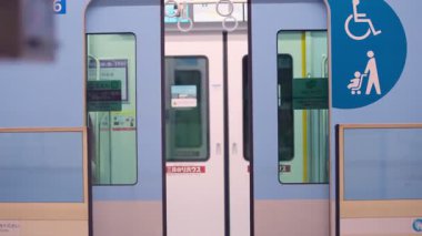 Fukuoka, Japonya-04 Ekim 2025: Şehir çevresindeki tramvay kapıları temiz bir platforma, modern geçiş davranışına ve temiz yapısal geometriye açılan banliyö trenleri yavaş çekim görüşü