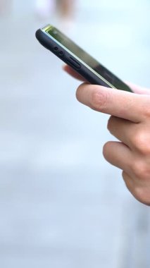 4K, Sevilla caddesinde tutulan ve daktilo kullanan Asyalı turist kadını kapat. Kız, İspanya 'da akıllı telefonları ve internette sörf yapmayı kontrol ediyor. Seyahat sırasında cihaz telefonu kullanan gezgin