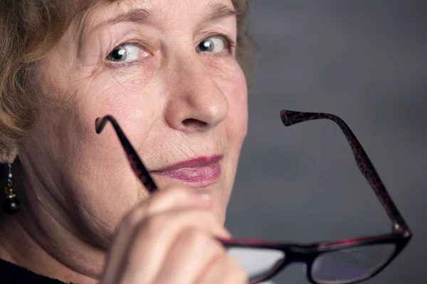 Portret van een mooie oudere vrouw met glazen — Stockfoto