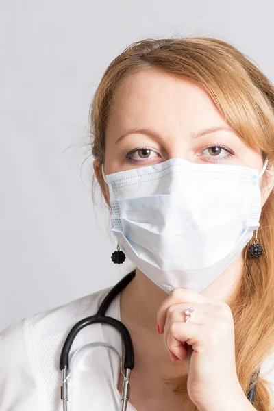 Cheerful girl doctor with stethoscope in a protective mask — Stock Photo, Image