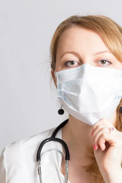 Wesoła dziewczyna lekarz z stetoskop w maskę ochronną — Zdjęcie stockowe
