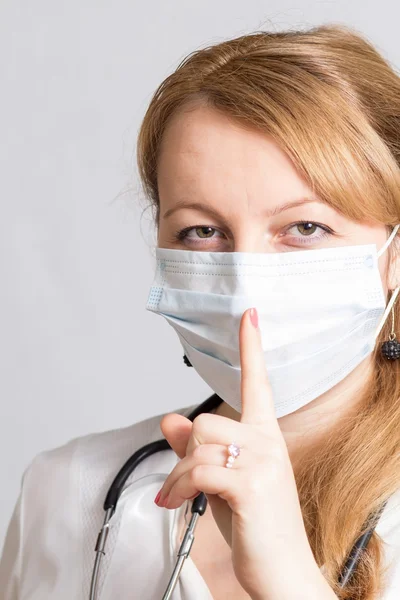 Nurse with stethoscope and a protective mask asks silence — Stock Photo, Image