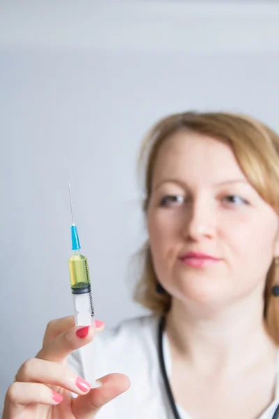 Doctor with stethoscope at the neck holding syringe for injection — Stock Photo, Image