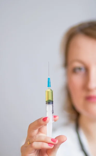 Doctor with stethoscope at the neck holding syringe for injection — Stock Photo, Image