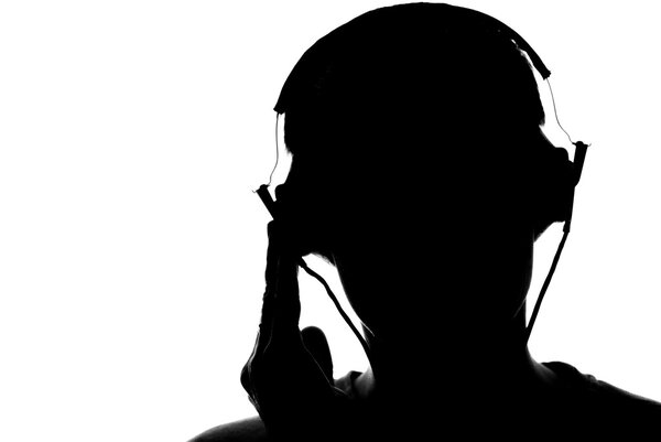 Силуэт молодого человека, слушающего музыку в наушниках
