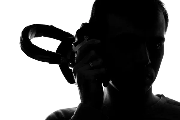 Silhueta de um jovem ouvindo música com fones de ouvido — Fotografia de Stock