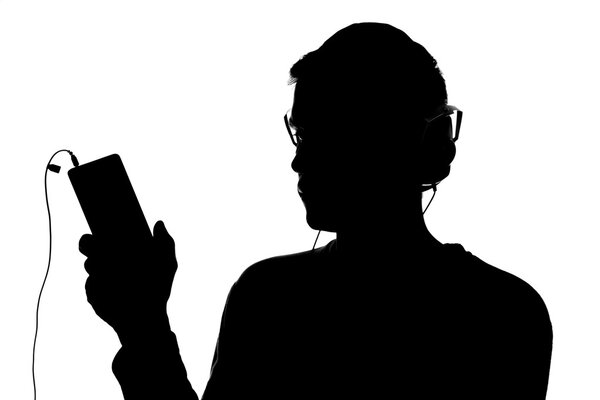 Силуэт молодого человека со смартфоном в наушниках
