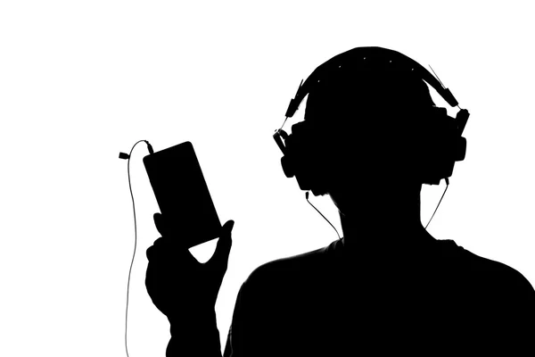 Silhouet van een jonge man met een smartphone met koptelefoon — Stockfoto