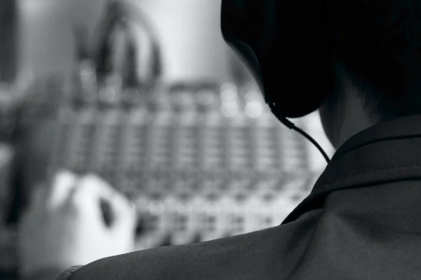 Homem com fones de ouvido e um mixer para ajustar o som — Fotografia de Stock