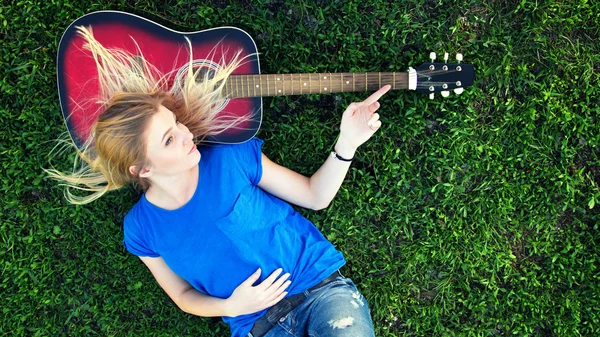 Portrait of a teenager with a guitar in the park — Stock Photo, Image