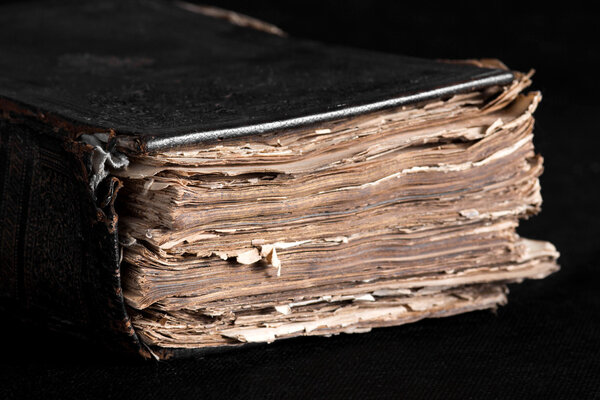 старая толстая книга на черном фоне на рабочем столе
