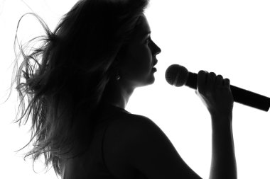 bir kadının elinde bir mikrofon ile şarkı silüeti