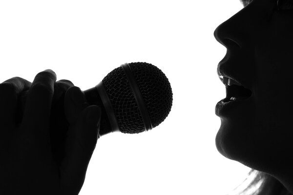 silhouette of a woman singing with a microphone in hands