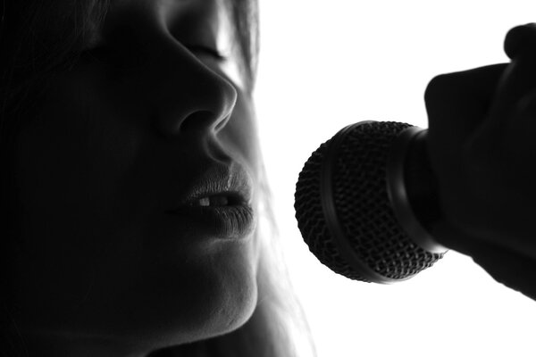 silhouette of a woman singing with a microphone in hands